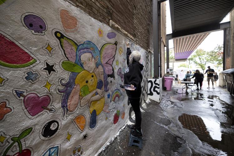 El sexto festival anual de arte callejón persiste a pesar de la lluvia.
